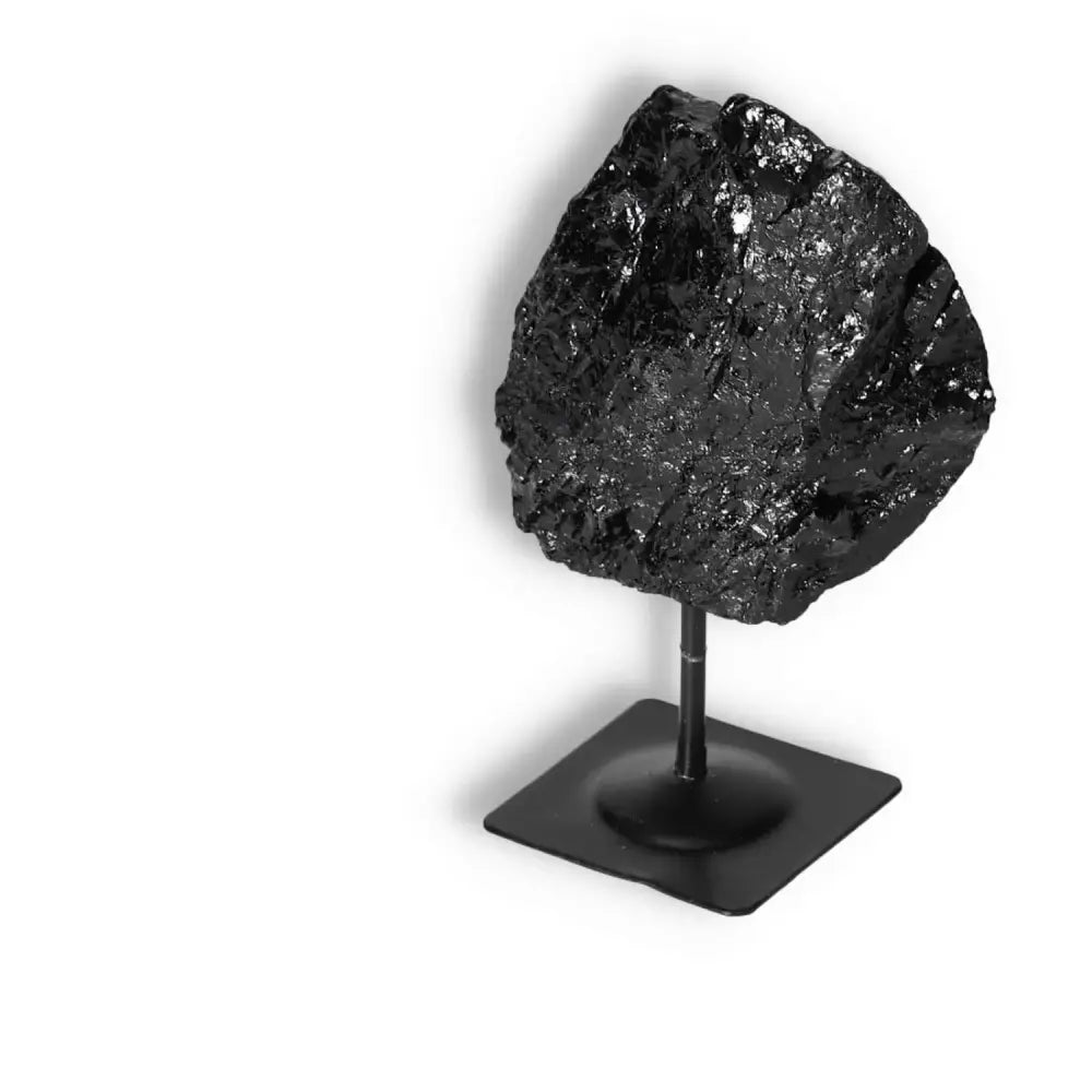 Rough Black Tourmaline on a Metal Stand by Sylvia Crystals, ideal for energy cleansing and mental stability enhancement.