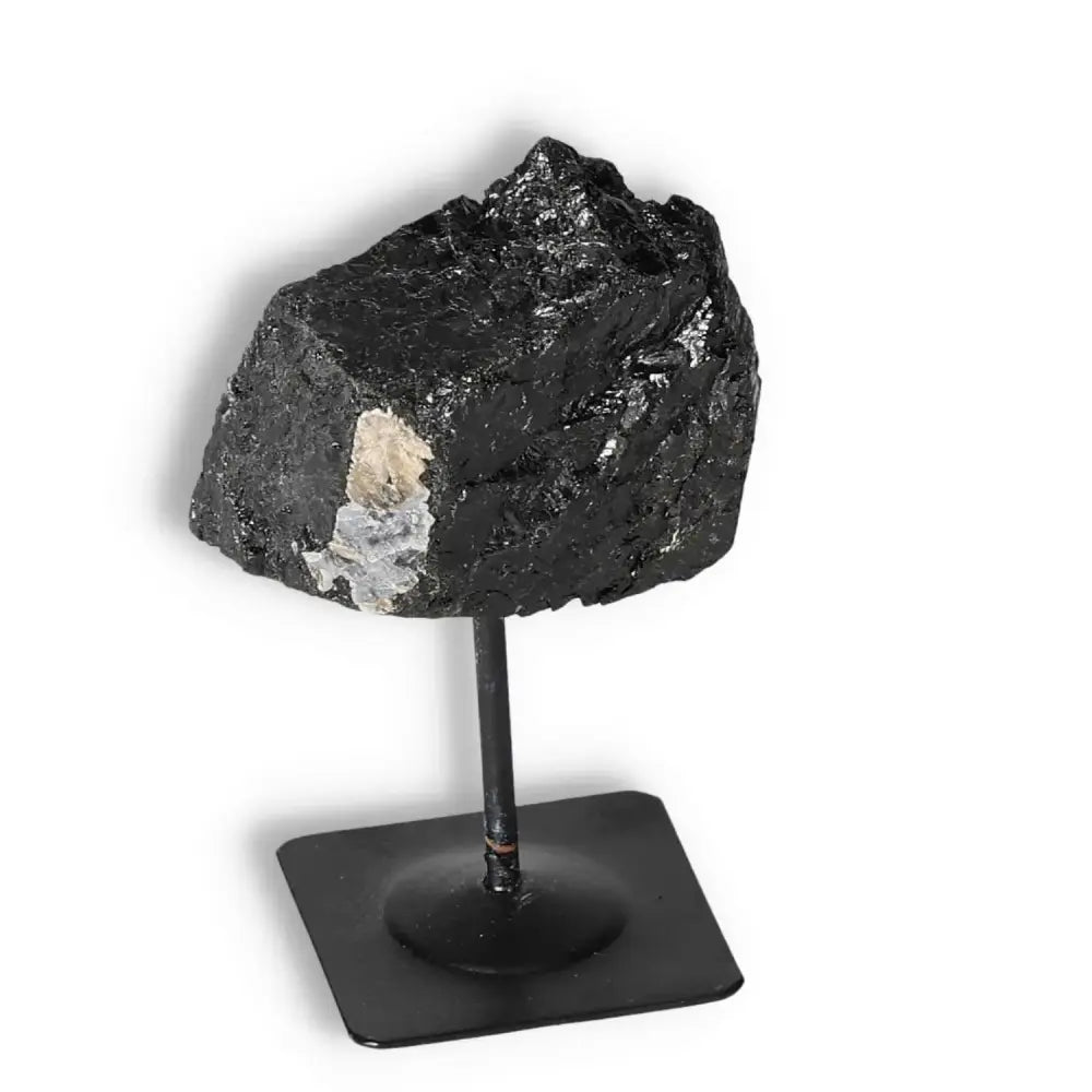 Rough Black Tourmaline on metal stand by Sylvia Crystals, showcasing natural artistry and spiritual depth for conscious luxury.