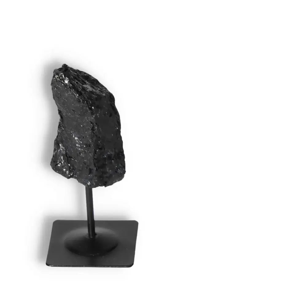 Rough Black Tourmaline on metal stand, offering elegance and energy cleansing, by Sylvia Crystals. Perfect for grounding and decor.
