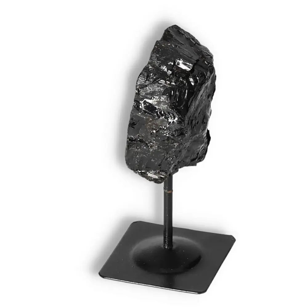 Rough Black Tourmaline gemstone on metal stand, perfect for energy cleansing and spiritual enhancement, by Sylvia Crystals.