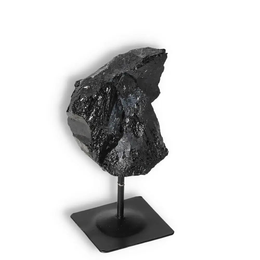 Rough Black Tourmaline on metal stand, ideal for energy cleansing and grounding, from Sylvia Crystals, perfect home decor piece.