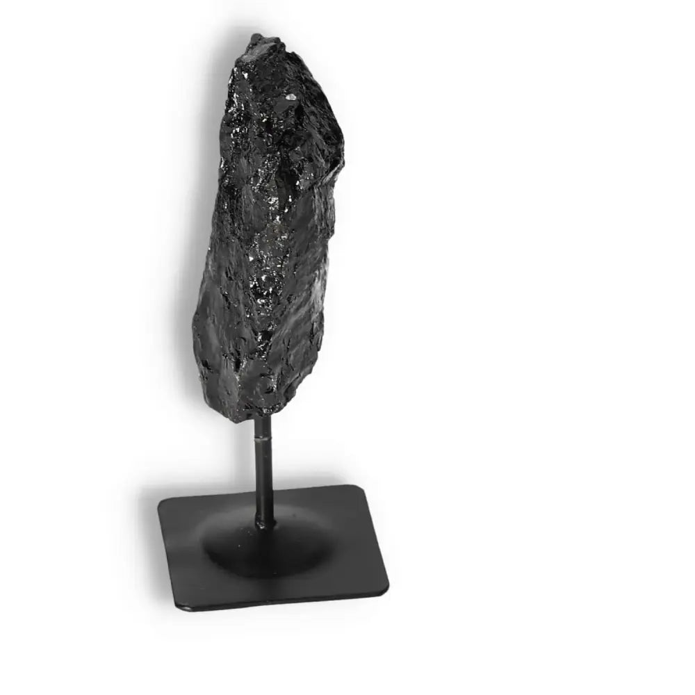 Rough Black Tourmaline on metal stand, ideal for dispelling negative energy, promoting mental balance, and enhancing the root chakra.