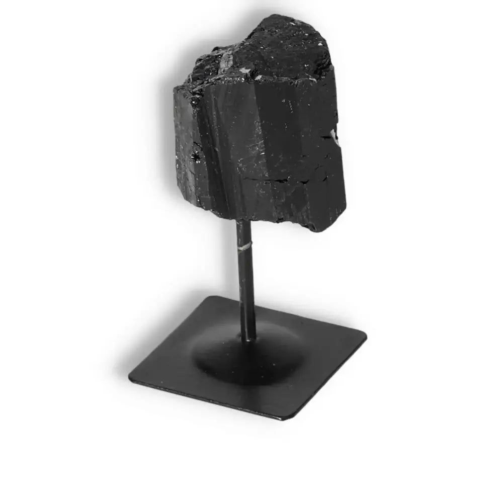 Elegant rough black tourmaline on a metal stand, perfect for spiritual harmony and mental balance, from Sylvia Crystals.