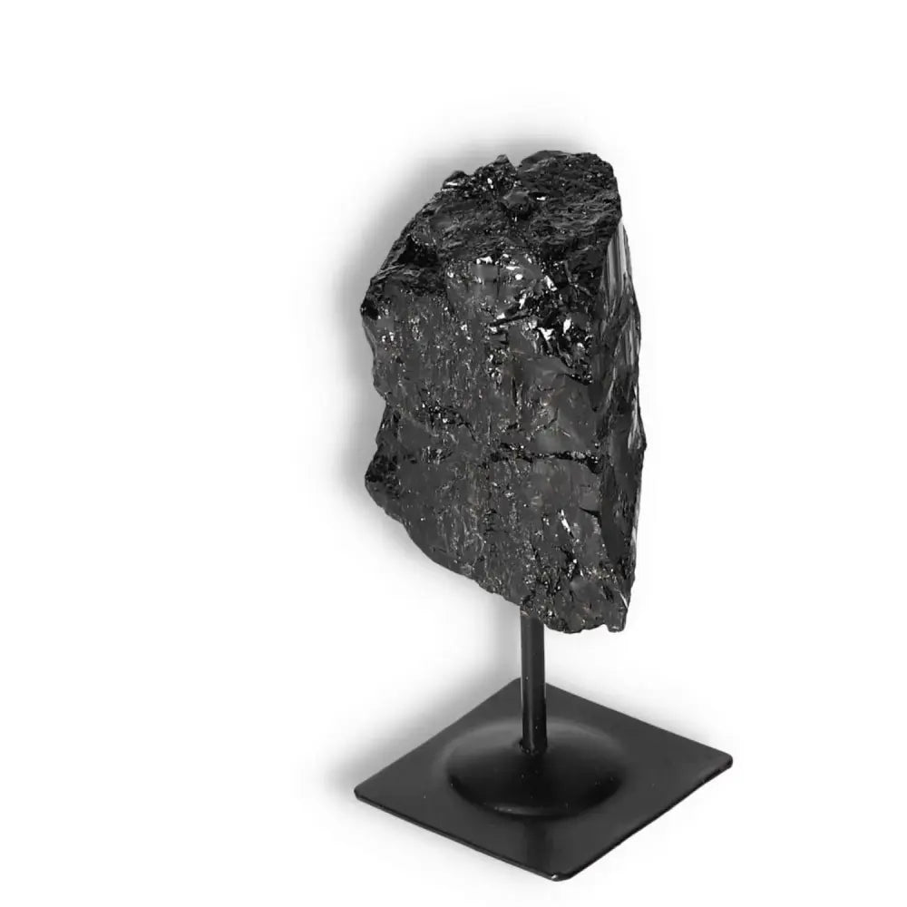 Rough Black Tourmaline with Metal Stand S by Sylvia Crystals, known for grounding and balancing energies, displayed on a sleek stand.