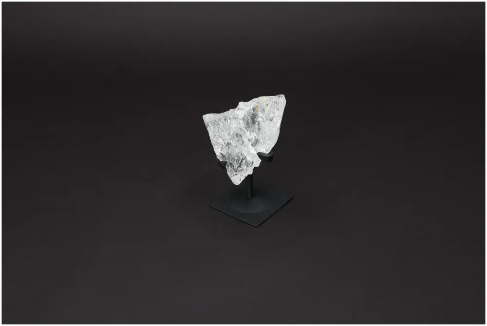 Rough Lemurian Quartz on a metal stand, enhancing decor and well-being with purification properties, by Sylvia Crystals.