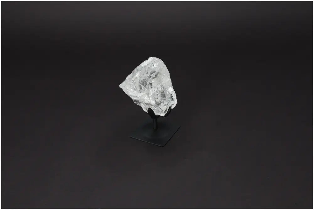 Rough Lemurian Quartz on Metal Stand by Sylvia Crystals, showcasing natural clear quartz with purification properties.