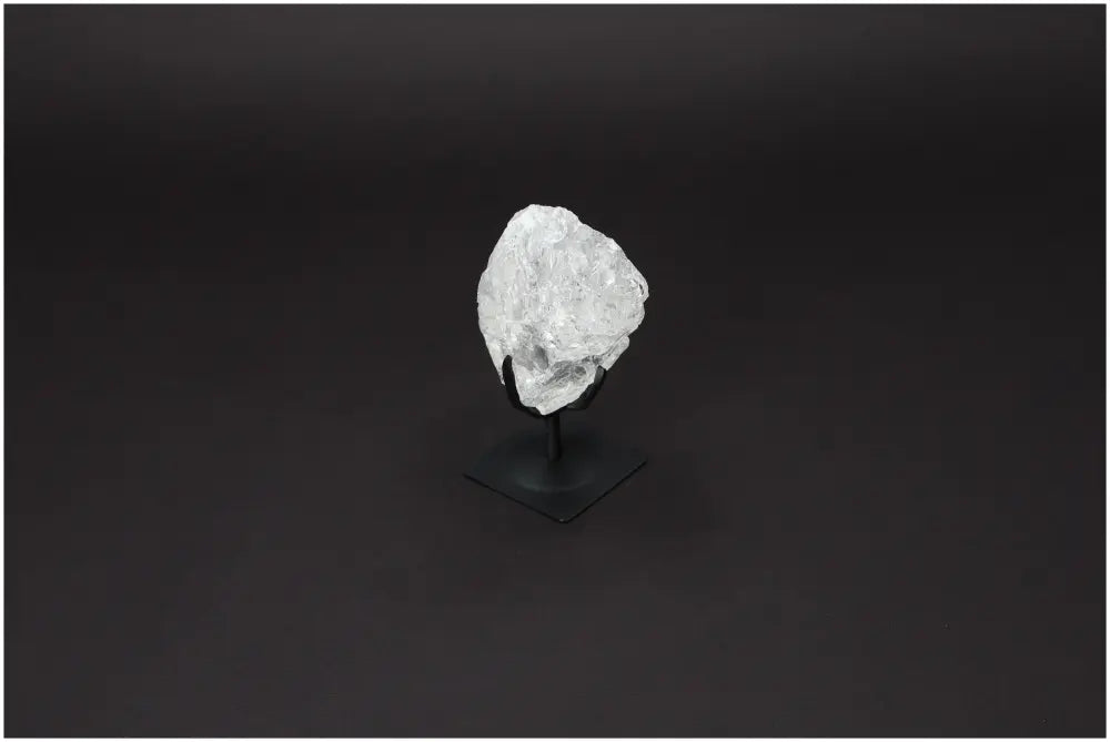 Rough Lemurian Quartz on metal stand by Sylvia Crystals, showcasing natural clear quartz for luxury and spiritual purification.