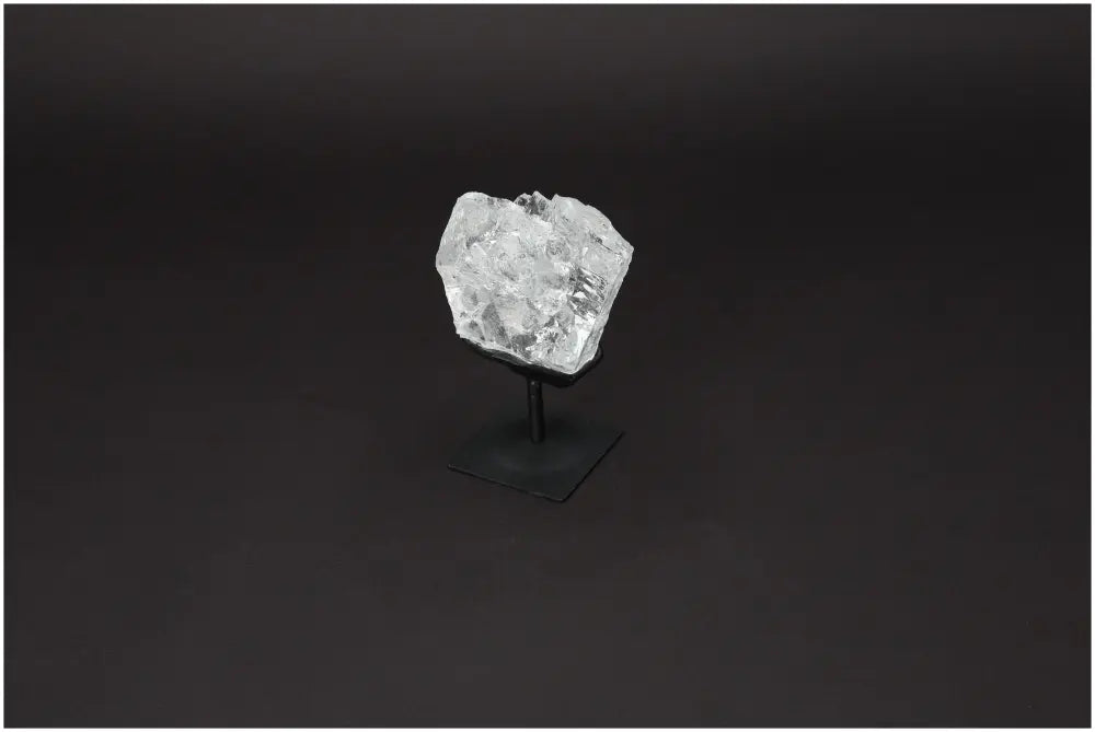 Rough Lemurian Quartz on metal stand, showcasing its natural purity and elegance from Sylvia Crystals.