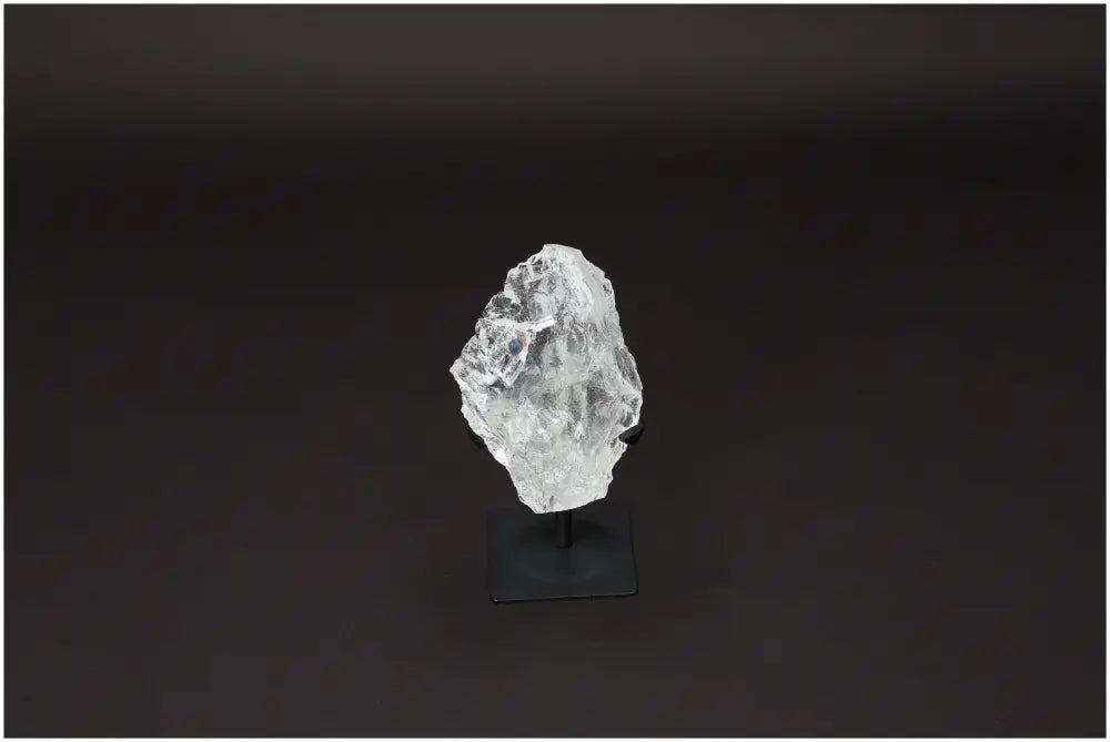 Rough Lemurian Quartz on metal stand, a premium Sylvia Crystals' product, harmonizes and balances energy, perfect for body and mind purification.