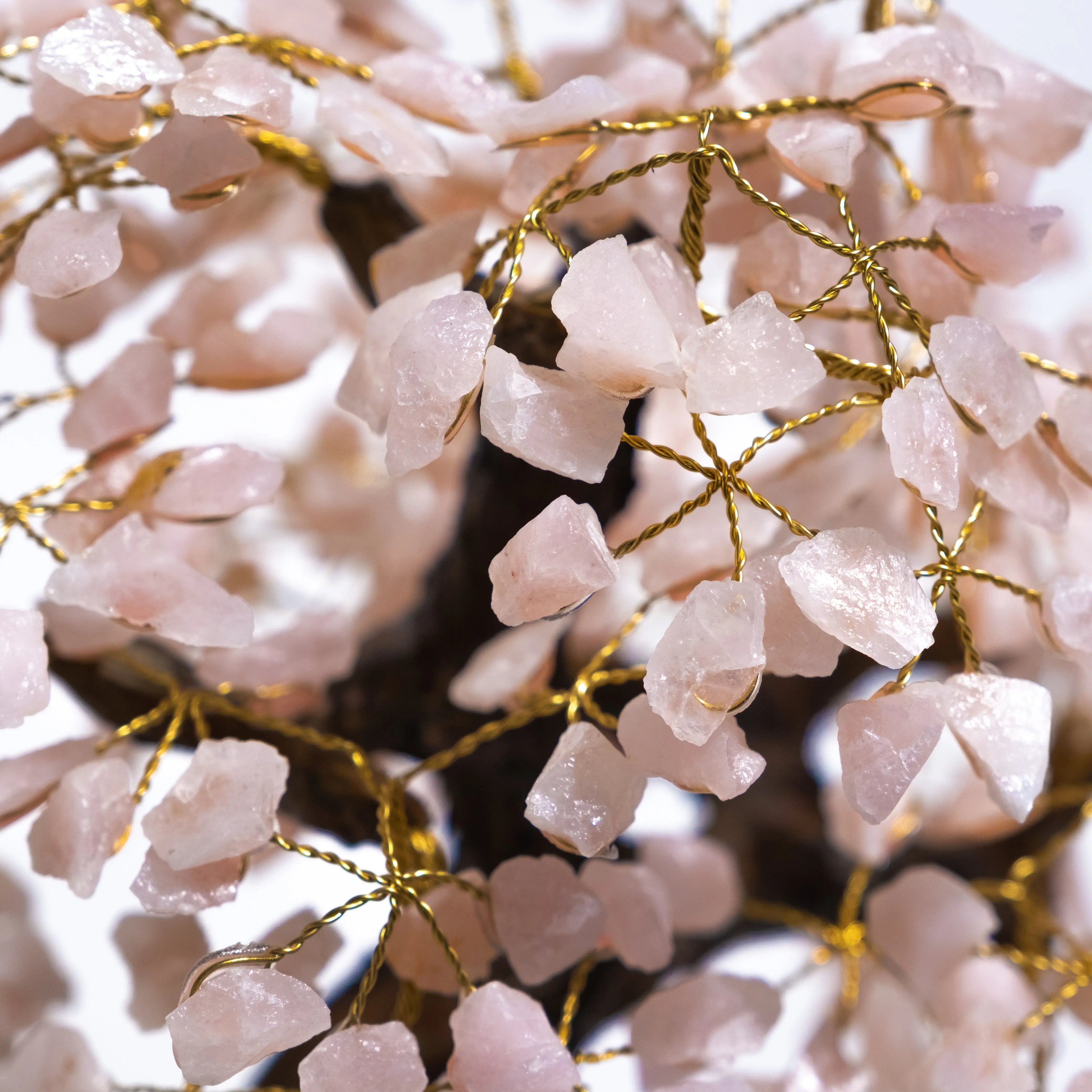 Close-up of a Rough Quartz Crystal Bonsai Tree with pink quartz leaves and gold wire branches, enhancing decor and energy balance.