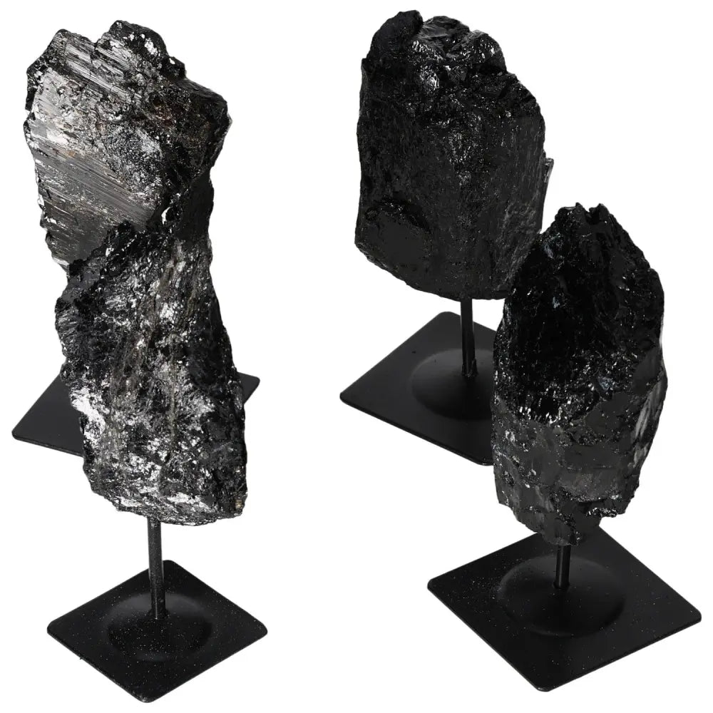 Rough Tourmaline stones on metal stands, showcasing varied textures and deep black hues, by Sylvia Crystals. Elegant home decor piece.
