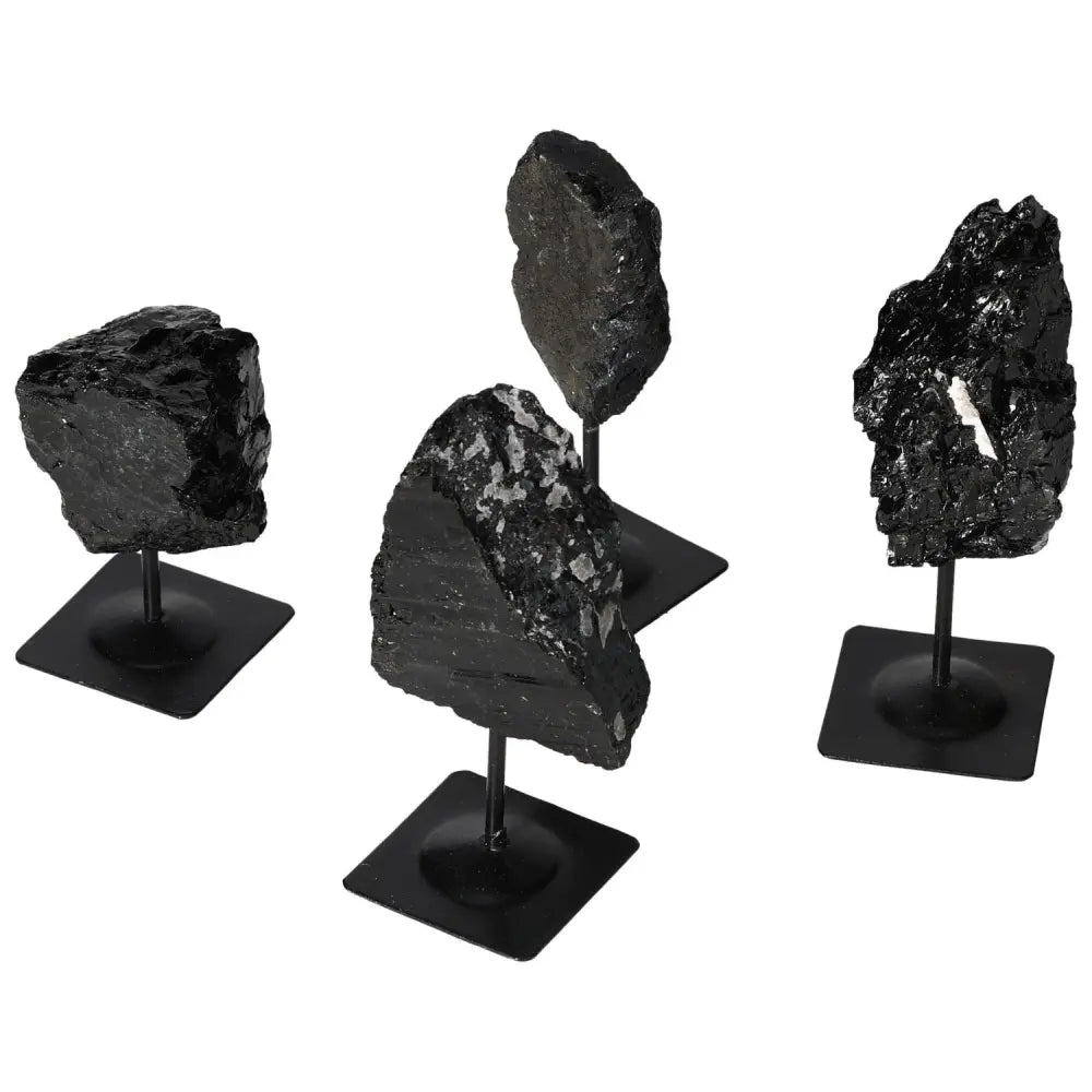Rough Tourmaline gemstones in black, mounted on metal stands, showcasing luxury and metaphysical elegance.