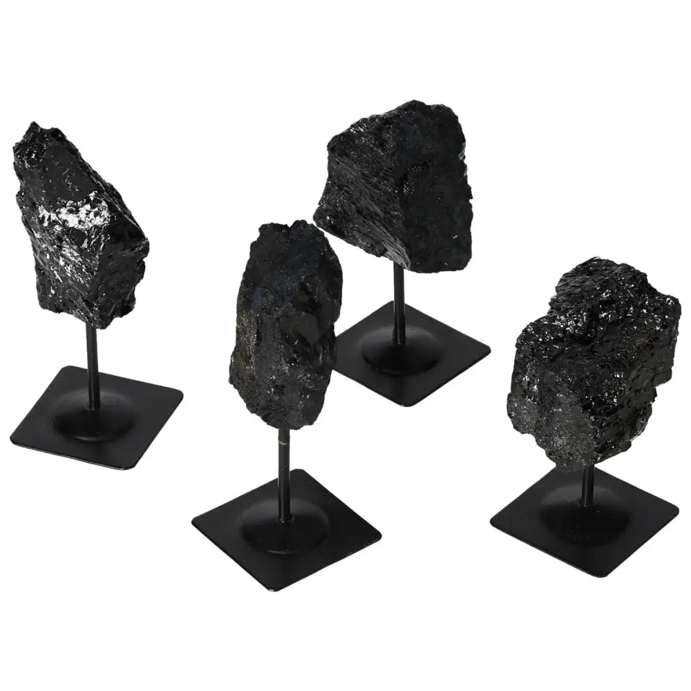 Rough Tourmaline gemstones on metal stands showcasing deep black hues, available from Sylvia Crystals.