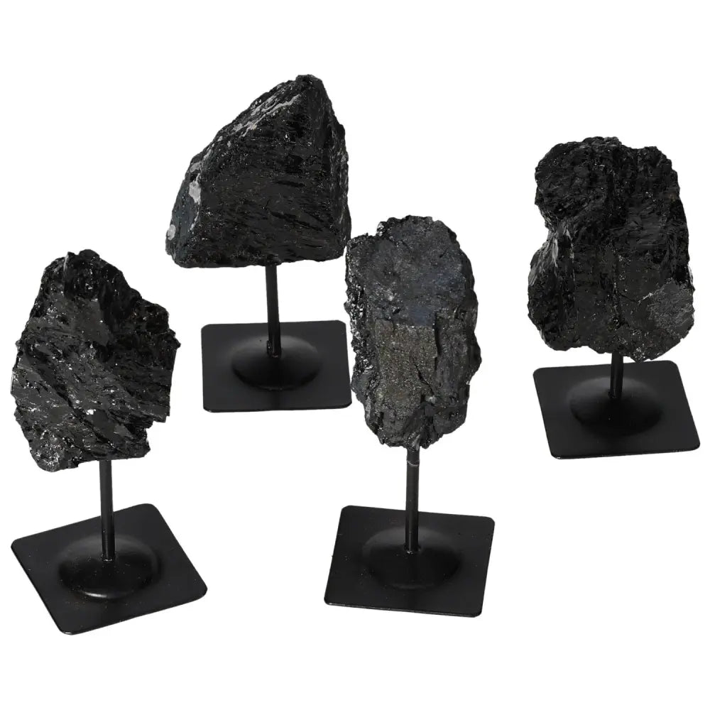 Rough tourmaline gemstones with metal stands showcasing deep black and vibrant green hues, by Sylvia Crystals.