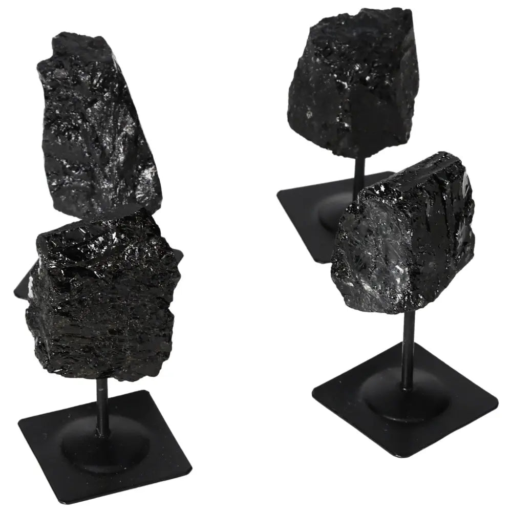 Rough black tourmaline crystals on sleek metal stands, showcasing natural beauty and artful design for home decor.