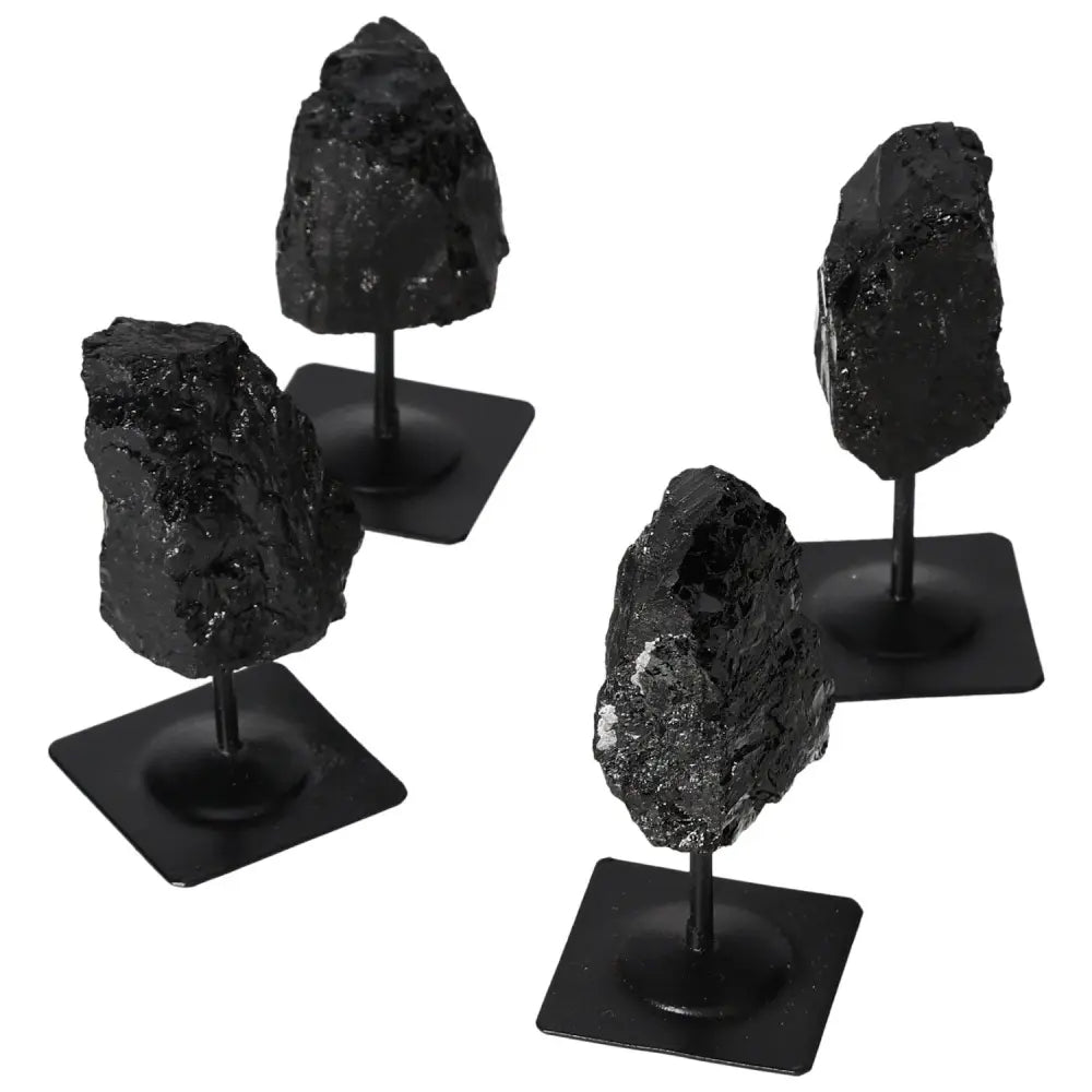 Set of black rough tourmaline stones on metal stands, showcasing their natural beauty and sleek design.