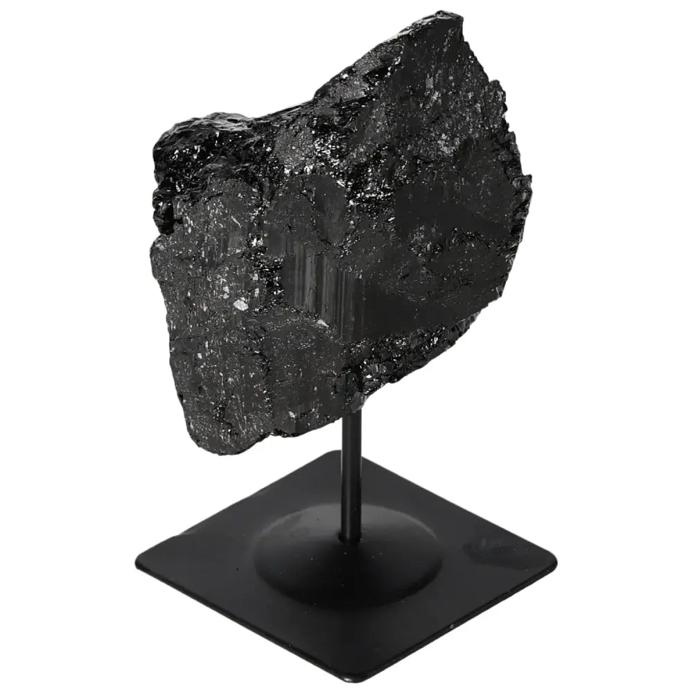 Rough black tourmaline crystal on a sturdy metal stand, ideal for enhancing home or office decor with luxury and spiritual harmony.