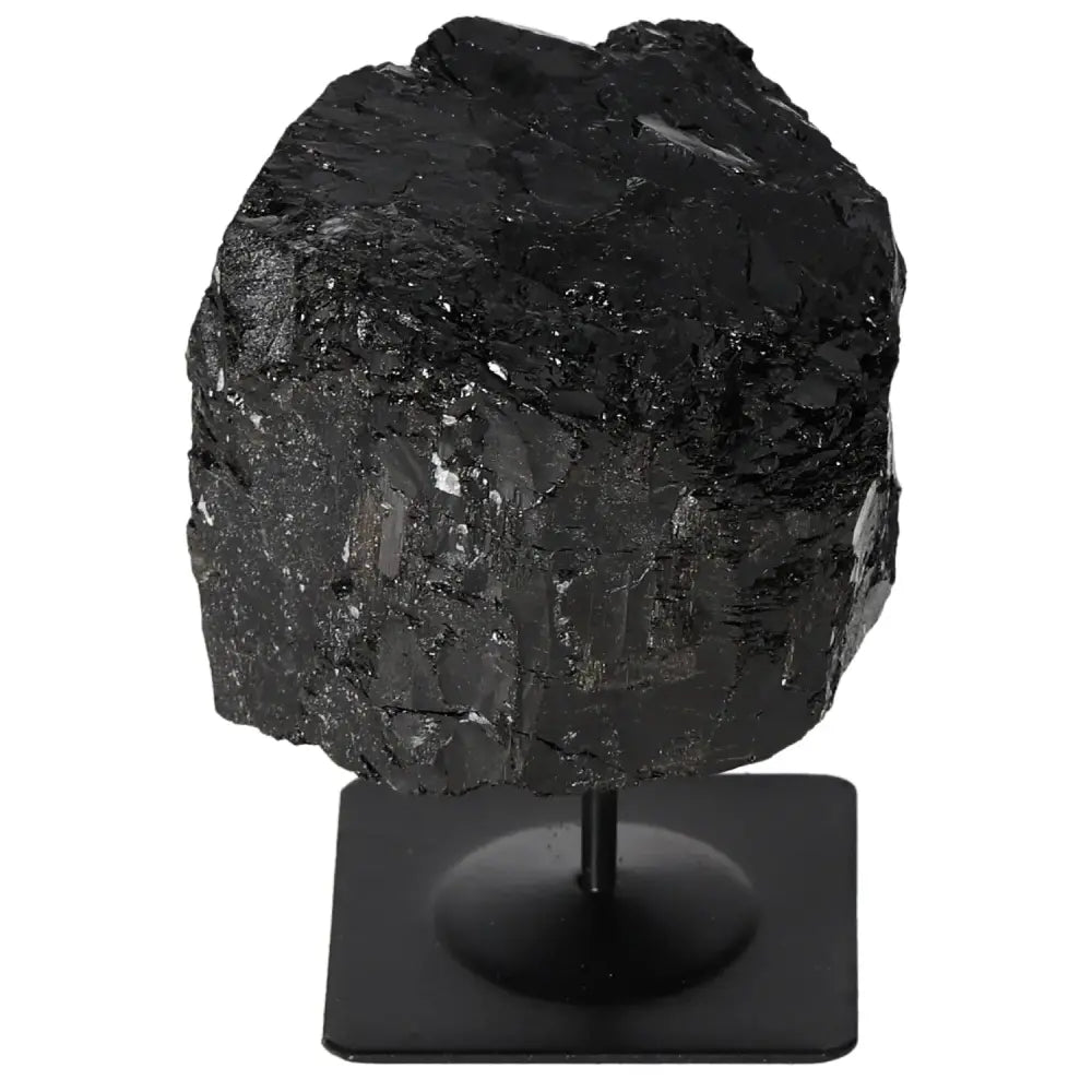 Rough black tourmaline crystal on a sturdy metal stand, showcasing raw beauty and natural splendor by Sylvia Crystals.
