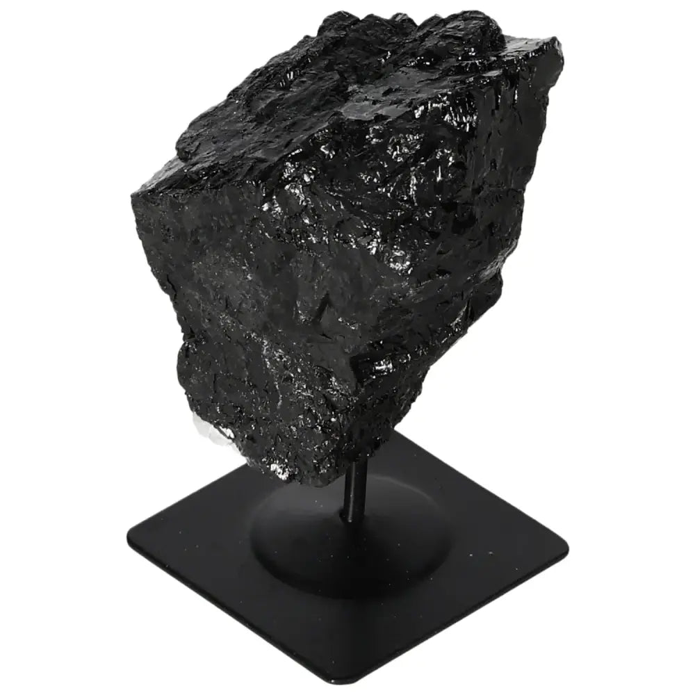 Rough black tourmaline crystal on a metal stand, showcasing raw, natural beauty, from Sylvia Crystals collection.