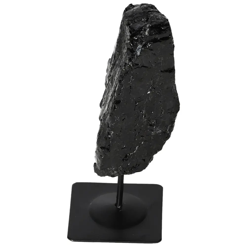 Rough black tourmaline stone on a metal stand, showcasing natural texture and elegance, handcrafted by Sylvia Crystals.
