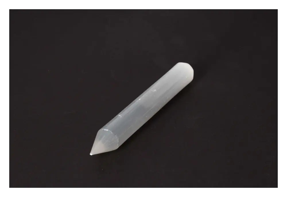 Selenite massage wand with a silky finish on a black background, ideal for energy purification and creating a harmonious atmosphere.