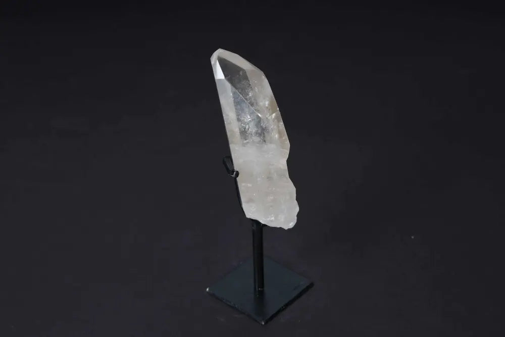 Semi polished clear quartz point on a stand, ideal for energy amplification, meditation, and modern decor.
