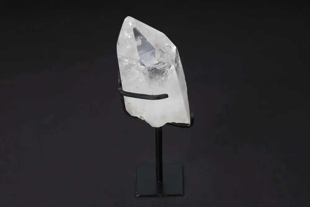 Semi polished clear quartz point on stand, amplifying energy, focusing intention, ideal for meditation and energy work display.
