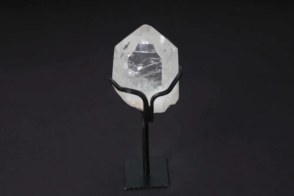 Semi polished clear quartz point on modern stand, ideal for amplifying energy and enhancing meditation spaces.