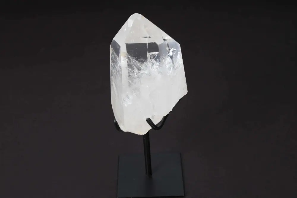 Semi-polished clear quartz point on stand, enhances energy and clarity, ideal for meditation and manifestation.
