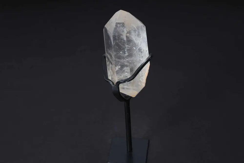 Semi polished clear quartz point on a stand for energy amplification and clarity, perfect for meditation and decoration.