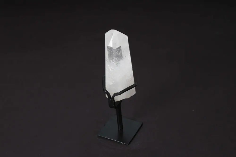 Semi polished clear quartz point on modern stand for energy amplification and clarity in meditation and healing practices.