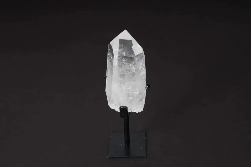 Semi polished clear quartz point on stand for amplifying energy, clarity, and focus; ideal for meditation and manifestation.