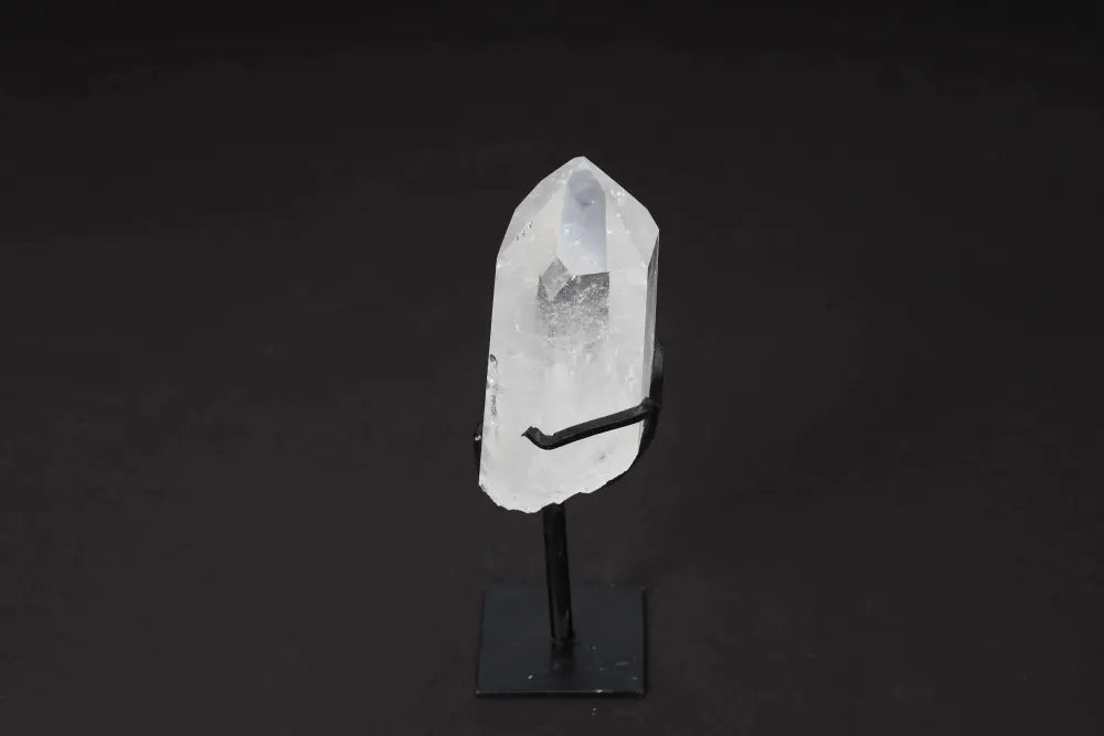 Elegant semi-polished clear quartz point on a sleek stand, ideal for amplifying energy and clarity in meditation spaces.