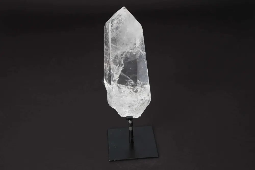 Semi Polished Clear Quartz Point on Stand, amplifying energy and clarity, ideal for meditation and manifestation purposes.