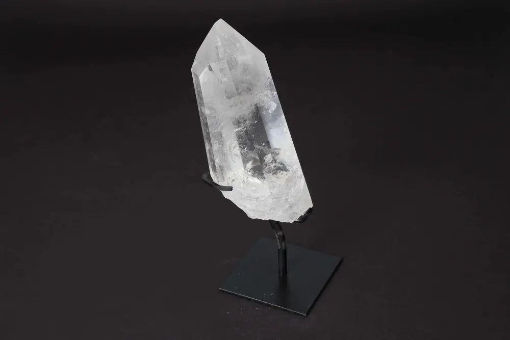 Semi polished clear quartz point on a modern stand, ideal for amplifying energy and enhancing meditation practices.