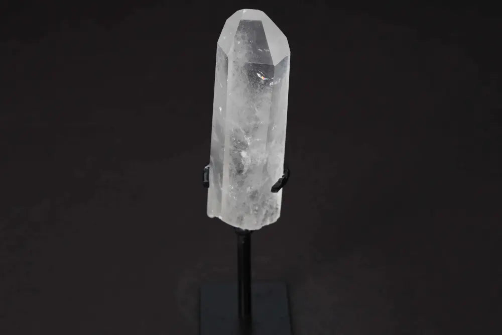 Semi Polished Clear Quartz Point on Stand, known for amplifying energy and clarity, ideal for meditation and energy work.