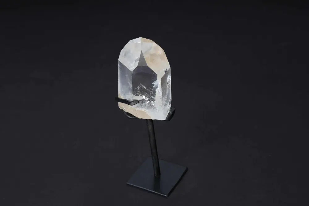 Semi-polished clear quartz point with stand, ideal for amplifying energy and clarity in meditation and energy work.