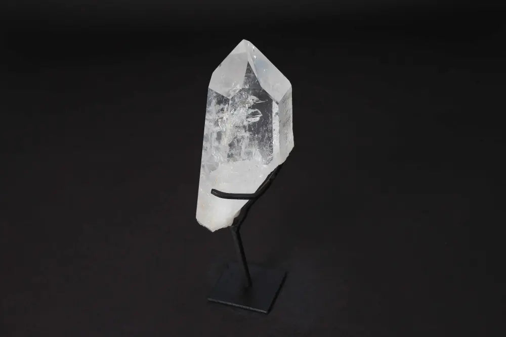 Semi-polished clear quartz point on modern stand, ideal for meditation and energy amplification, enhancing clarity and focus.