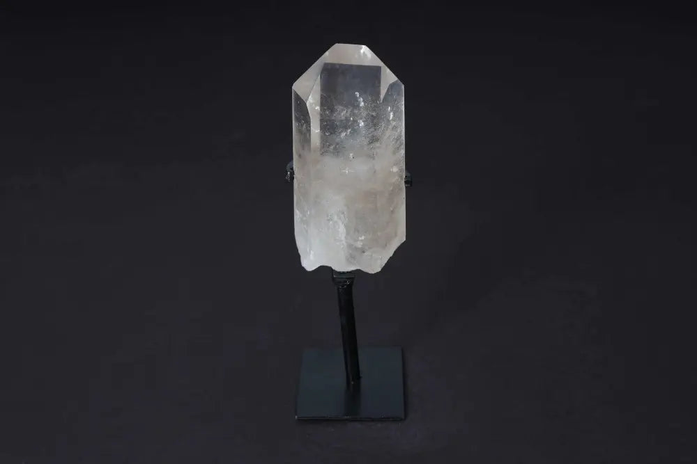 Semi-polished smoky quartz point on stand, showcasing earthy tones and raw edges, ideal for decor and grounding energy.