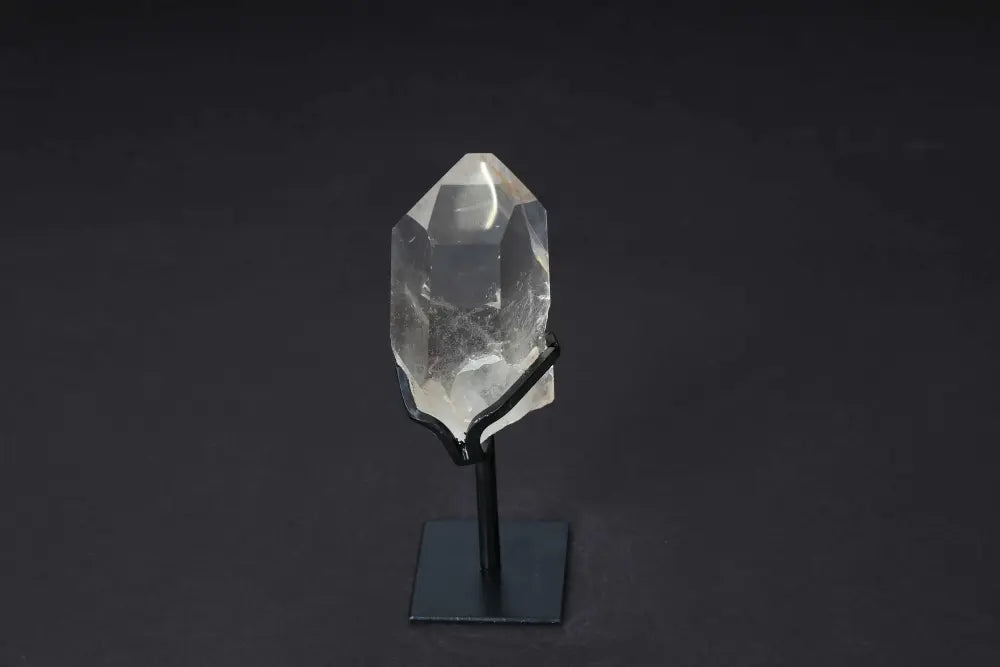 Semi-polished smoky quartz point on stand, highlighting natural tones and polished faces for grounding and protective energy