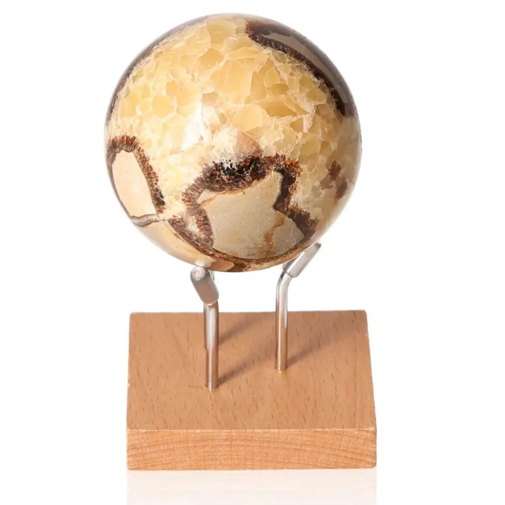 Alt Tag: Polished Septarian Sphere on wooden stand, known as Dragon Stone, showcasing unique yellow patterns and brown mineral details.