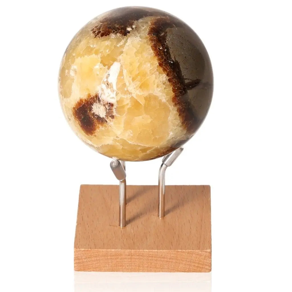 Septarian Sphere on a wooden stand showcasing its unique patterns, symbolizing power and endurance in its striking multicolored design.