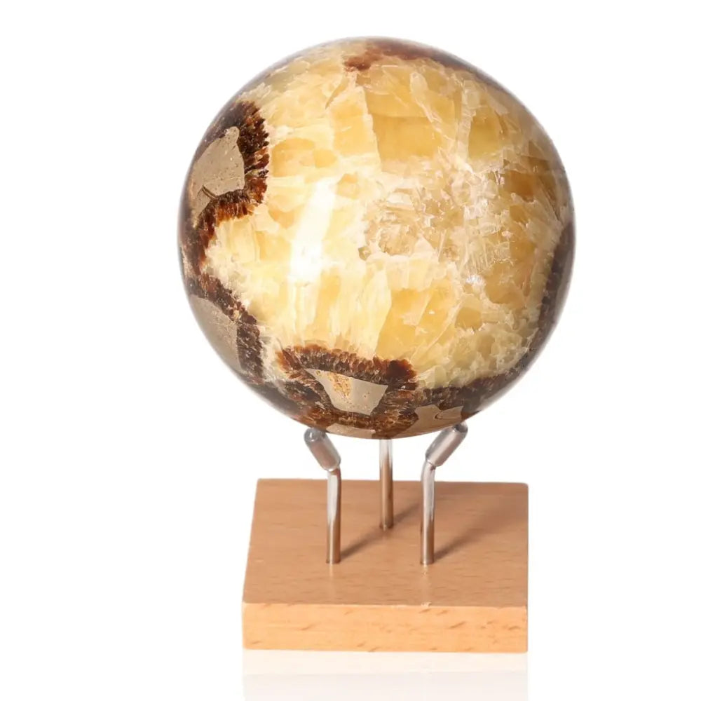 Polished Septarian Sphere on wooden stand, showcasing unique patterns and colors, symbolizing endurance and spiritual growth.
