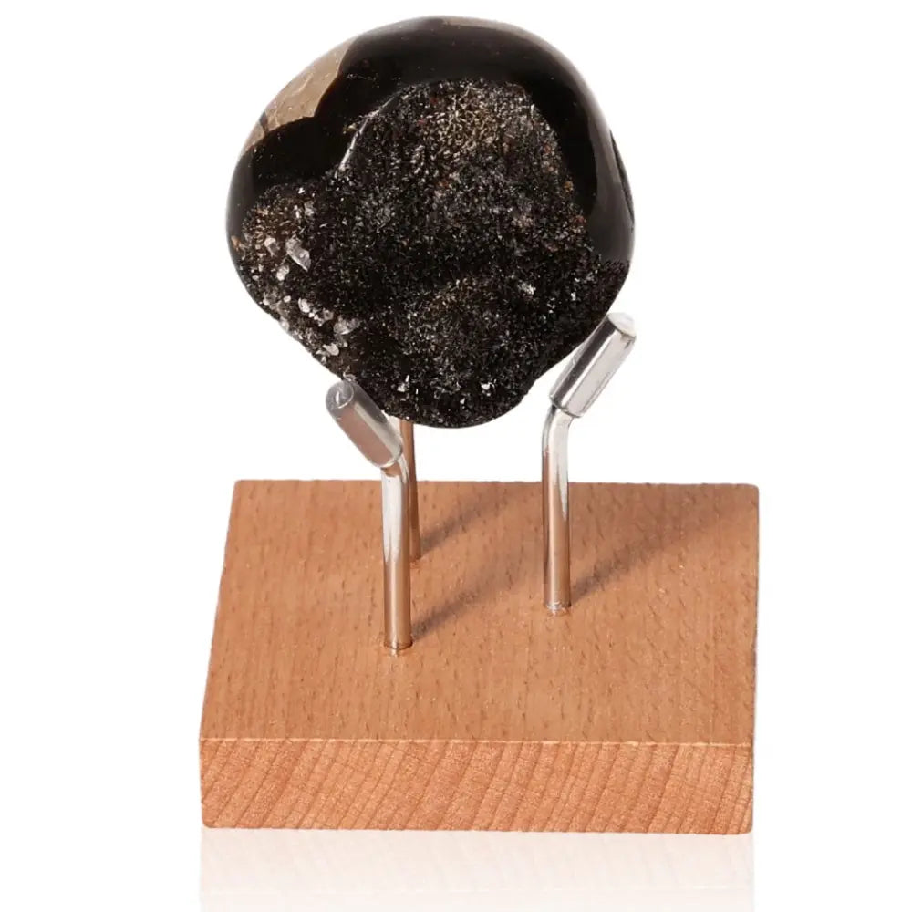 Septarian "Dragon Stone" on wooden stand showcasing unique mineral appearance and symbolism.