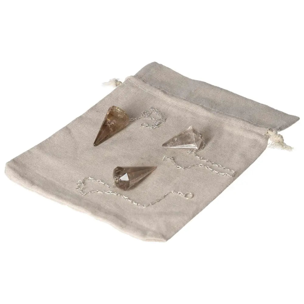 Smoky Quartz pendulums displayed on a linen pouch, ideal for decision-making, grounding, and clear thinking in professional settings.