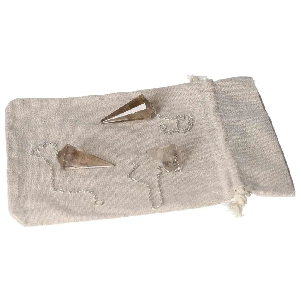 Three smoky quartz pendulums on a cloth bag, ideal for grounding and enhancing decision-making in business and personal life.
