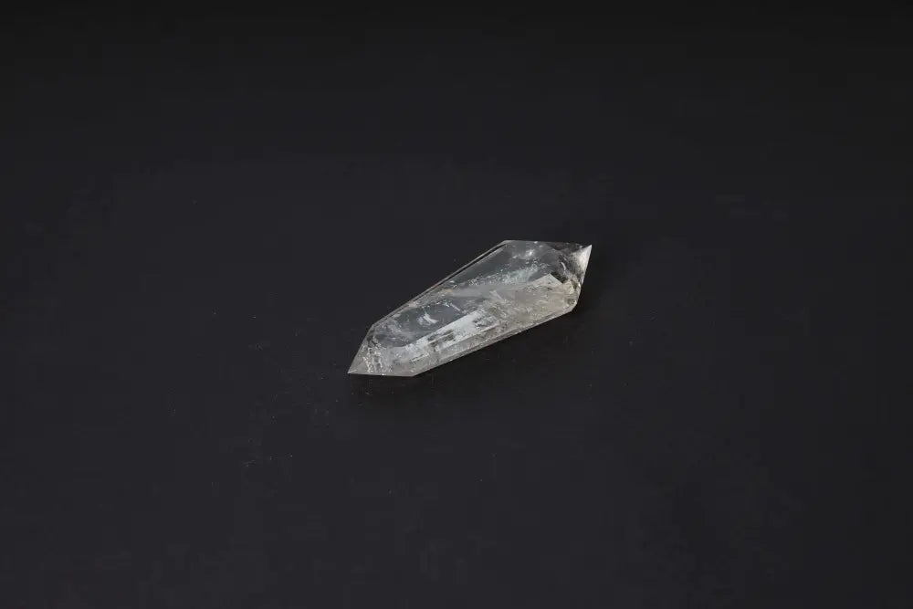 Polished smoky quartz point on black background, showcasing grounding and protective properties with translucent smoky tones.