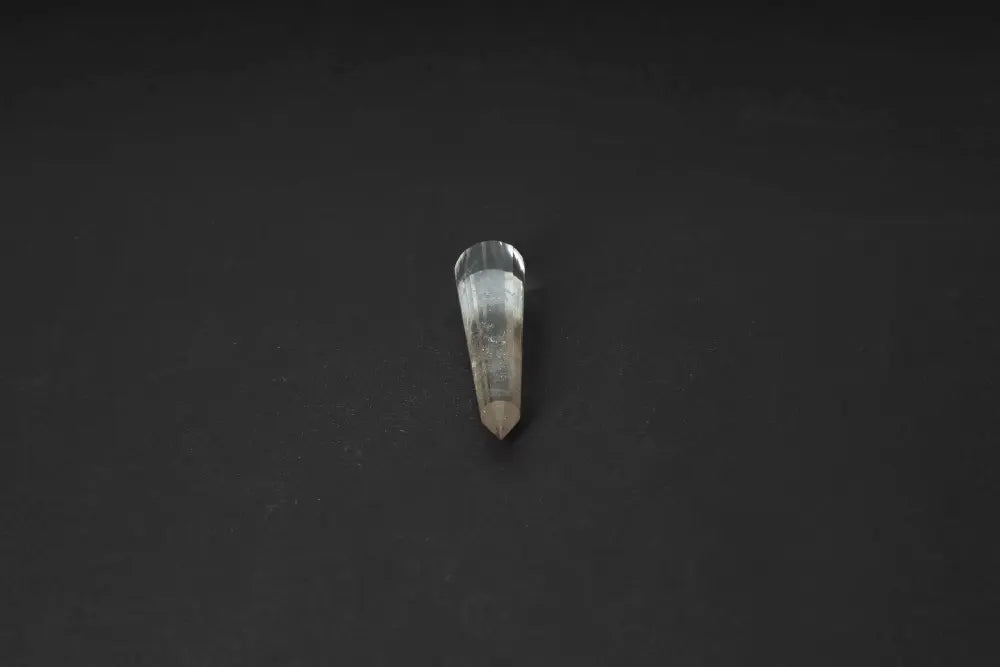 Smoky Quartz Point on black background, showcasing its translucent brown tones for grounding and protection.