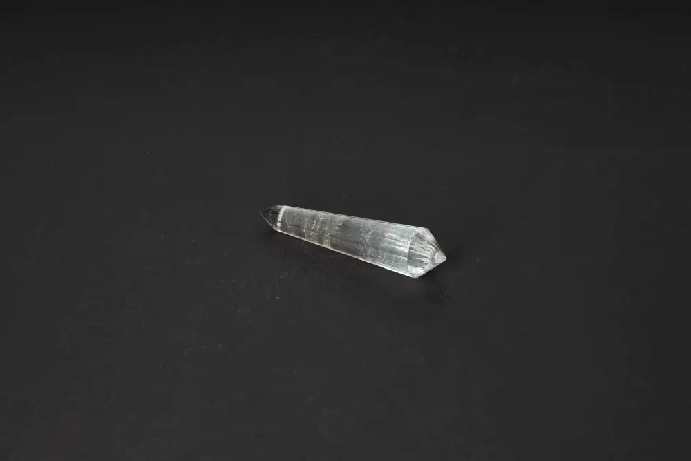 Smoky Quartz Point on a dark background showcasing its translucent, grounding qualities.