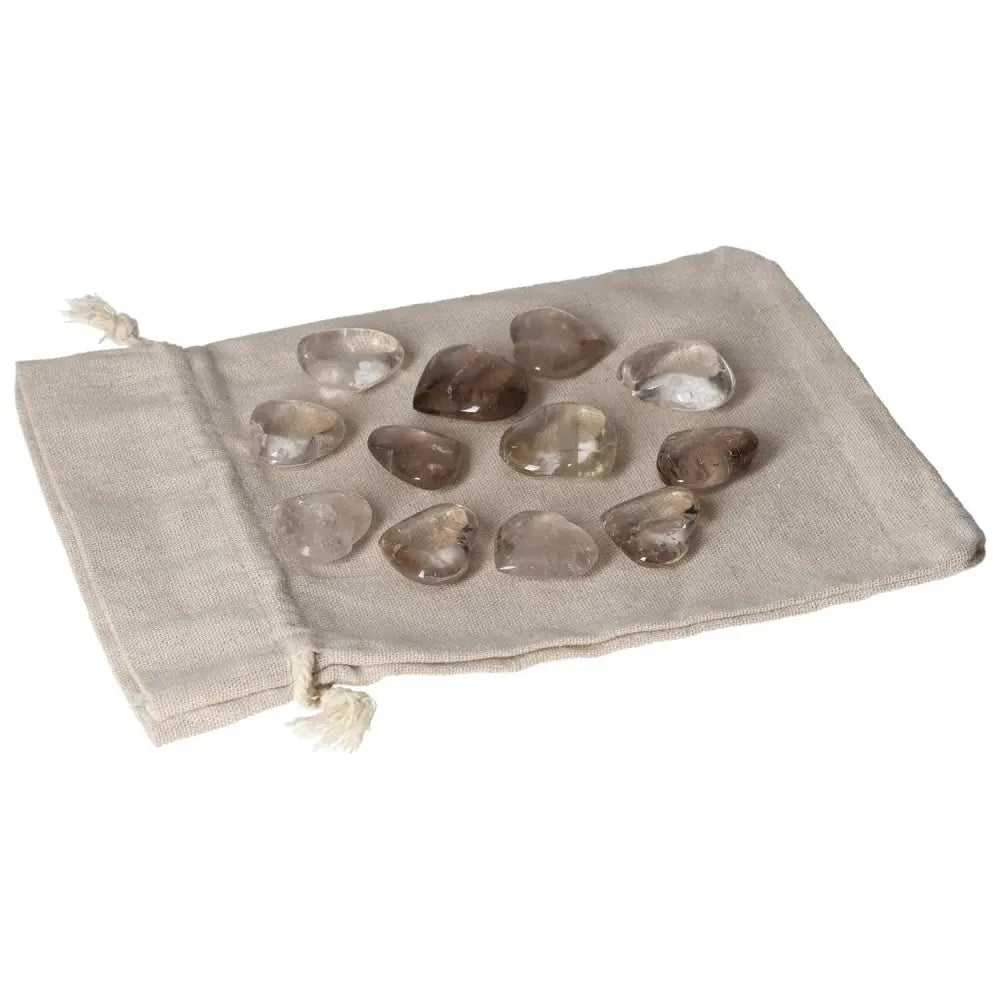 Collection of smoky quartz small heart stones on a fabric pouch, known for enhancing practical thinking and decision-making.